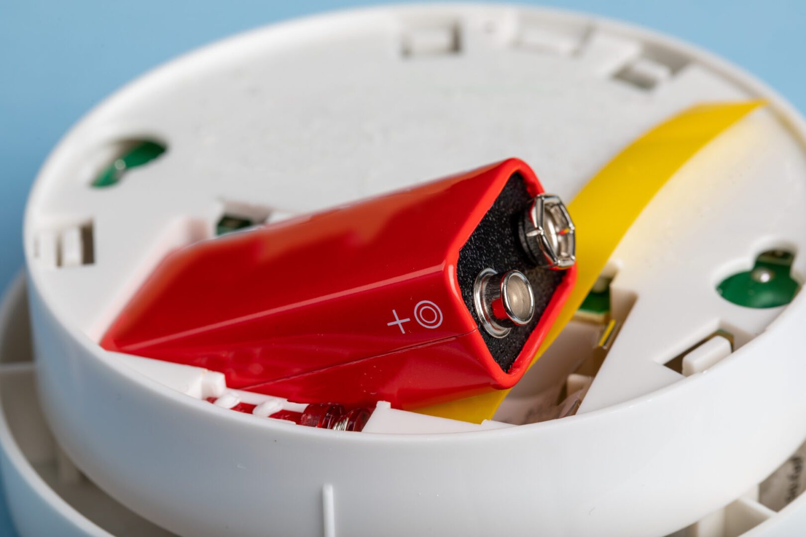 a smoke and fire detector showing the battery being installed